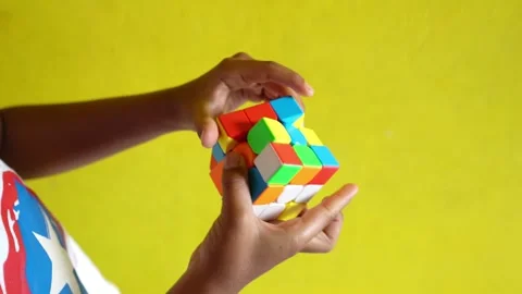 A young boy's hands playing with a colorful 3D puzzle Stock Footage 300249953