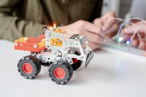 Young boys having fun constructing robot cars at the workshop Stock Photos