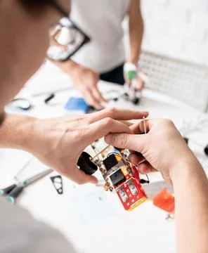 Young boys having fun constructing robot cars at the workshop Stock Photos