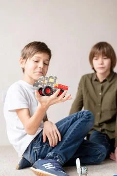 Young boys having fun constructing robot cars at the workshop Stock Photos