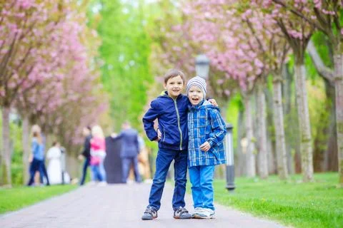 Young boys smiling while standing on lane in park Stock Photos