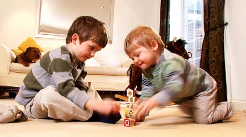 Young boys stacks play bricks until they collapse. Stock-Footage 32960593