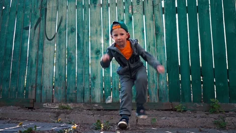 Young breakdancer dances on the background of the old green wooden fence Stock Footage 89130273