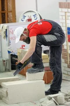Young bricklayer performs a task of competition Stock Photos