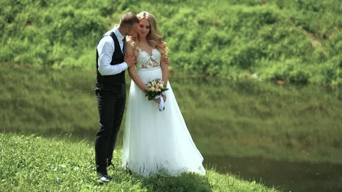 Young bride and groom posing near the river in the autumn. Wedding day. Vídeos de archivo 95473372