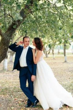 Young bride and groom walking in a summer Park with green trees Foto stock