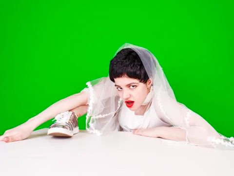 The young bride climbs with difficulty on an imaginary high obstacle, an obst Stock Photos