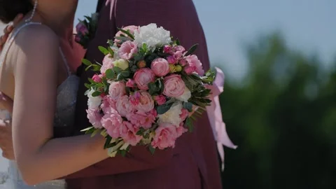 Young bride hugging her husband on her wedding day with a wedding bouquet in her Stock Footage 306154823