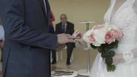 Young bride puts golden wedding ring on groom's hand in wedding house Stock Footage 306144717