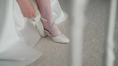 A young bride puts on her white wedding shoes Video stock 329092292