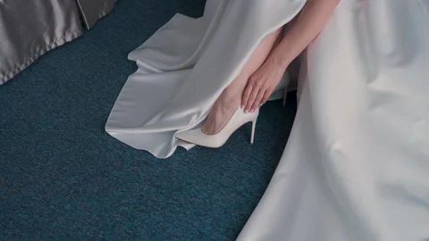 A young bride puts on her white wedding shoes Vídeos de archivo 329094172