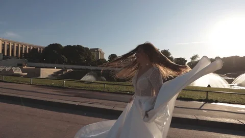 Young bride running in slow motion waving dress and long veil on background of Stock Footage 128595795