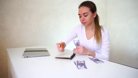 Young bride sitting near table with laptop and distributing money for wedding Vídeo Stock 82047771
