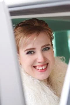 Young bride smiles happily while sitting in a car. Stock Photos