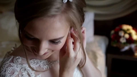 Young bride is smiling and putting on an earring Stock Footage 69828066