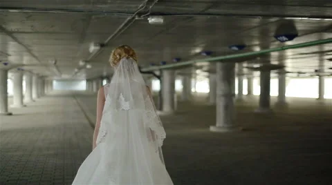 A young bride in a white wandering alone about the parking. Middle shot Stock Footage 49115297