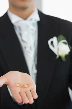 Young bridegroom showing wedding rings Stock Photos