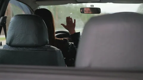 Young brown-haired woman knocks on the steering wheel of a broken car Stock Footage 88833078