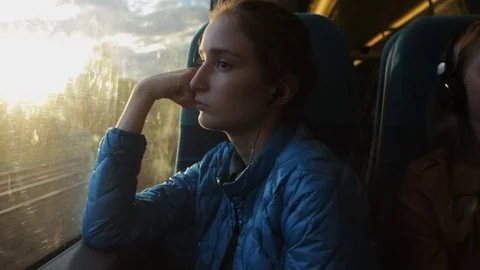 Young brunette beautiful hipster girl looking to the window in the train and Stock Footage