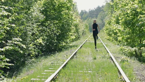 Young brunette in a black suit performs physical exercises on the background of Stock Footage 89856370