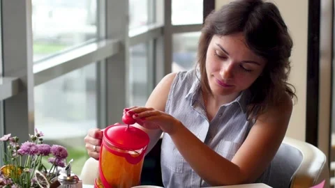 Young brunette is drinking tea in a cafe. woman eating breakfast in a cafe 動画素材 138817023