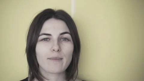 Young brunette eats pop corn. Pop corn sprinkles from above. Yellow background Stock Footage 132453143
