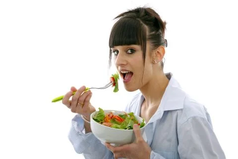 Young brunette eats salad Stock Photos