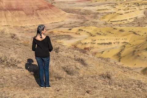 A young brunette with gray strands observes the landscape from Painted Hills Foto stock