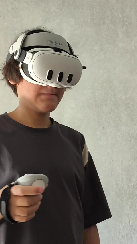 A young brunette guy with VR glasses is playing video games in a virtual world 動画素材 313267622