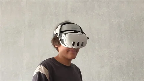 A young brunette guy with VR glasses is playing video games in a virtual world Видео 313267852
