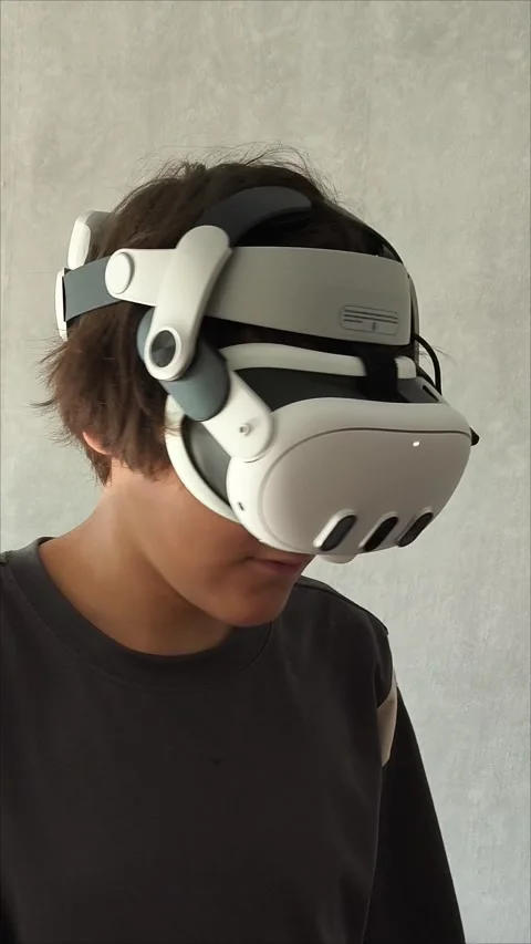 A young brunette guy with VR glasses is playing video games in a virtual world Stock Footage 313267993