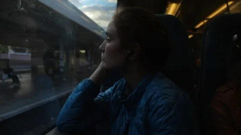 Young brunette hipster girl looking to the window in the train and thinking Stock Footage