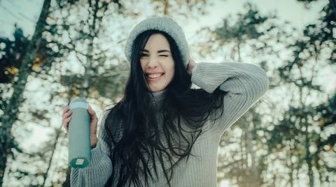 Young brunette makes faces at camera in winter forest Stock Photos
