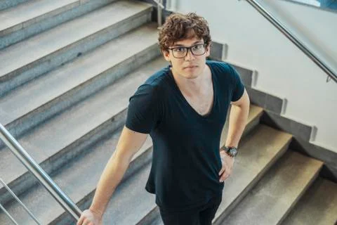 Young brunette man going down the stairs at metro station. Stock Photos