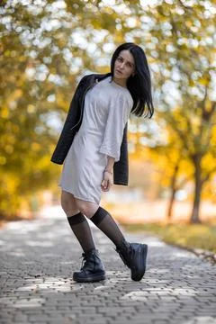 Young brunette model posing in the park against golden autumn Stock Photos