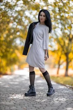 Young brunette model posing in the park against golden autumn Stock Photos