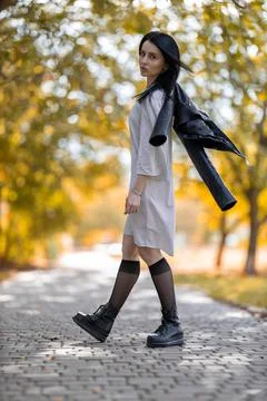Young brunette model posing in the park against golden autumn Stock Photos