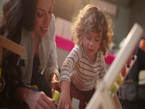 Young brunette mother playing with her blond son Stock Footage