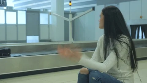 Young brunette nervous and wait her baggage in the airport Stock Footage