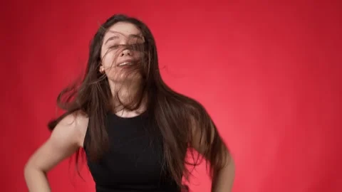Young brunette running energetically on spot against red background Stock Footage 249523944