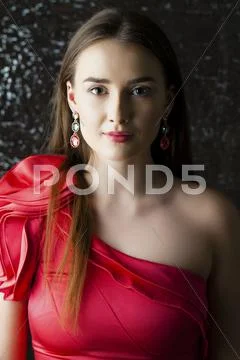 Young Brunette Woman On Dark Studio Wall Background