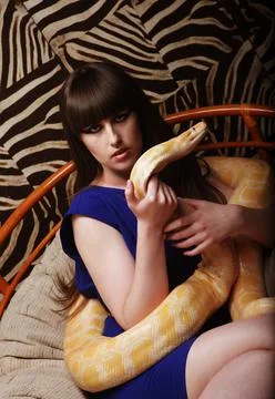 Young brunette woman holding python, big snake. Stock Photos