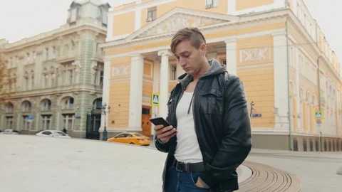 Young brutal man communicates with a partner in the messenger European city. Stock Footage 96312195