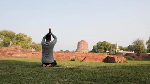 Young Buddhist devotee performing holy mediation at sarnath dhamek stupa ru.. Stock Footage 315727191