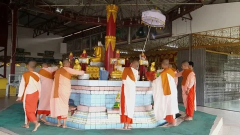 Young Buddhist nuns perform ritual and pour water over Buddha statues at basin Видео 80910324