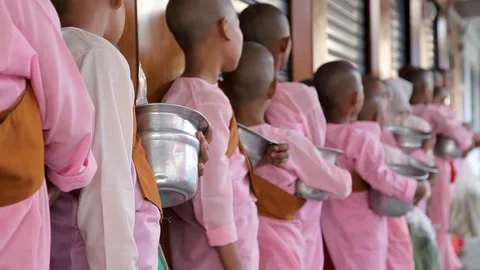 Young buddhist students waiting in line to be served food Video stock 114379258