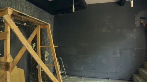 Young builder accurately paints wall with gray suffusion in art studio Stock Footage 66181577