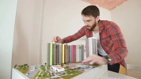 Young builder assemble complex building model, construction. Stock Footage 128104943
