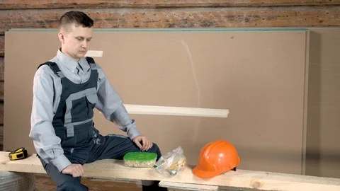 The young builder got hungry working at a construction site. Lunch break at the  Video stock 102776786
