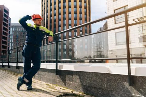 Young builder in special clothes looking into the distance against the backgr Stock Photos